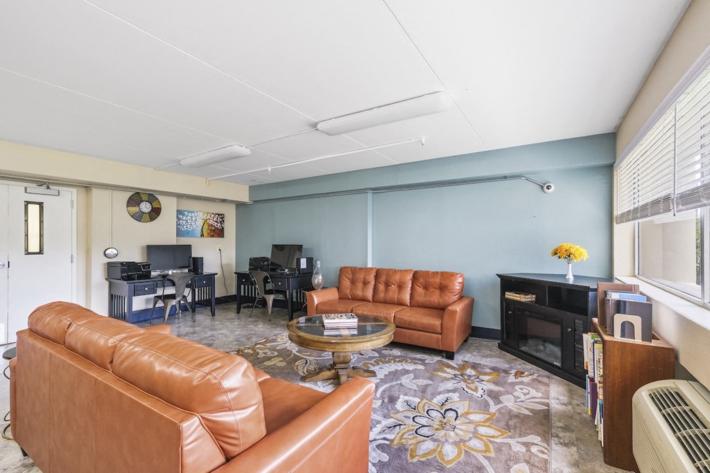 a living room with leather couches and a table and a television