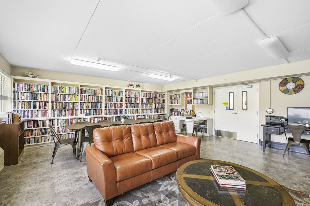 a living room with a couch and a table in front of a library