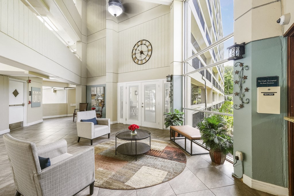 a lobby with chairs and a table and a clock on the wall