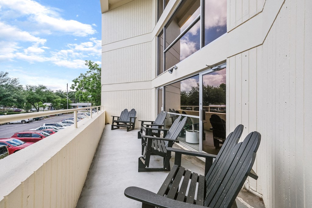 the outlook of a patio with chairs and tables outside of a building