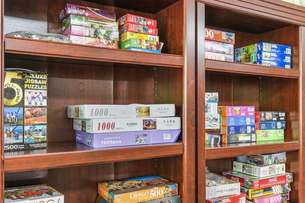 a variety of board games sit on shelves in a library