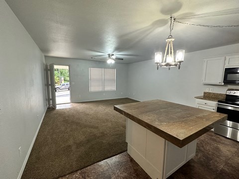 A kitchen with a brown countertop and white cabinets.