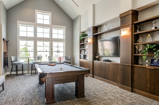 a large game room with a pool table and a tv