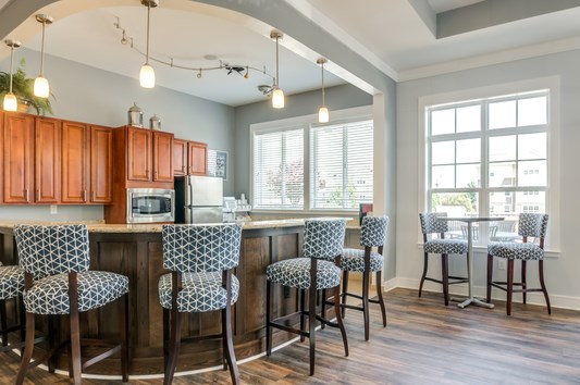a kitchen with bar stools and a counter with chairs