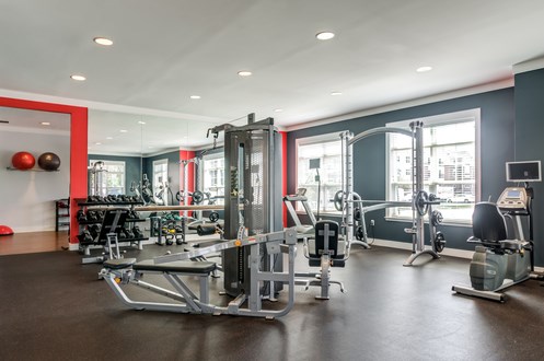 a gym with weights and cardio equipment on the floor and windows