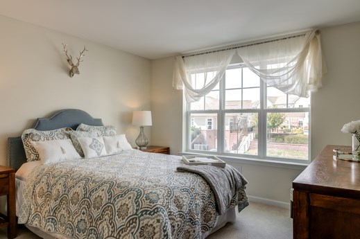 a bedroom with a bed and a large window