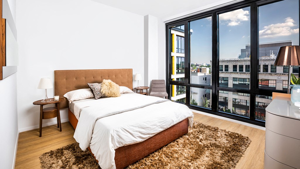 a bedroom with a bed and a large window