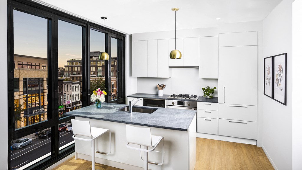a kitchen with white cabinets and a large window