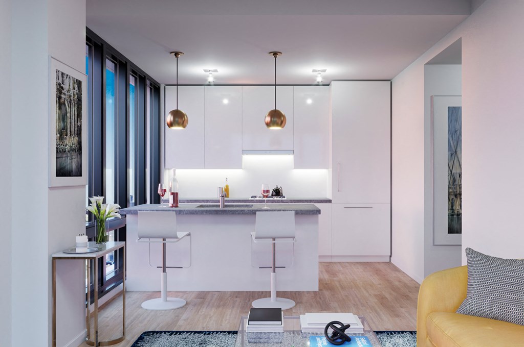 a kitchen with white cabinets and a bar with stools