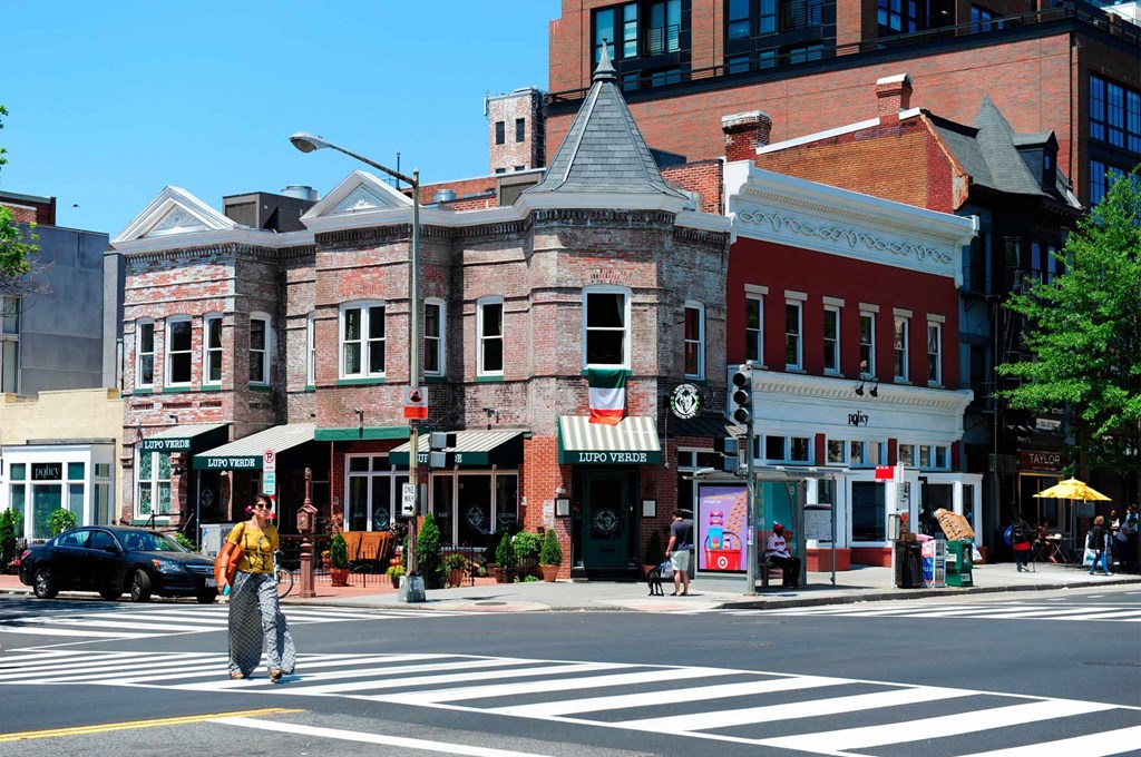 a man crossing the street at a crosswalk in front of a building