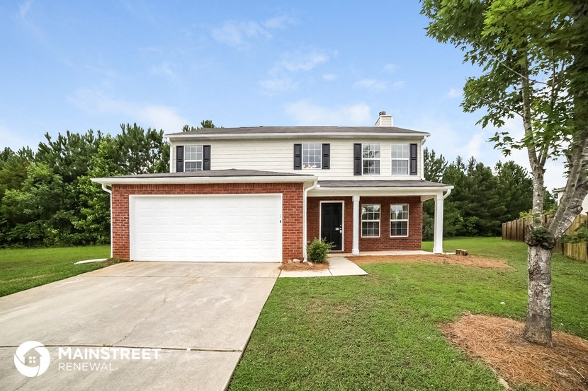 a brick house with a white garage door and a lawn