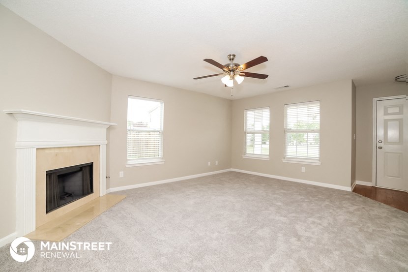 the living room with fireplace and ceiling fan