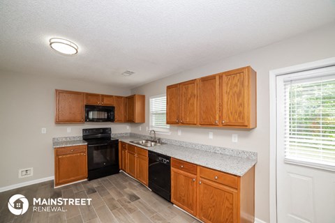 a kitchen with wooden cabinets and a counter top and a sink