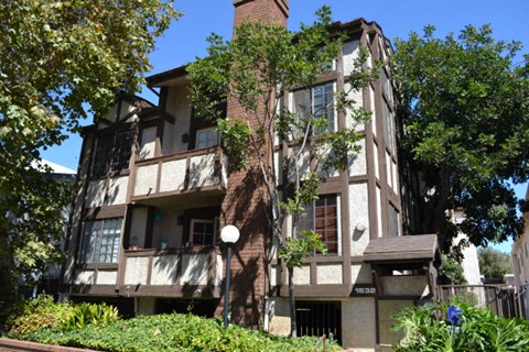 an apartment building with trees in front of it