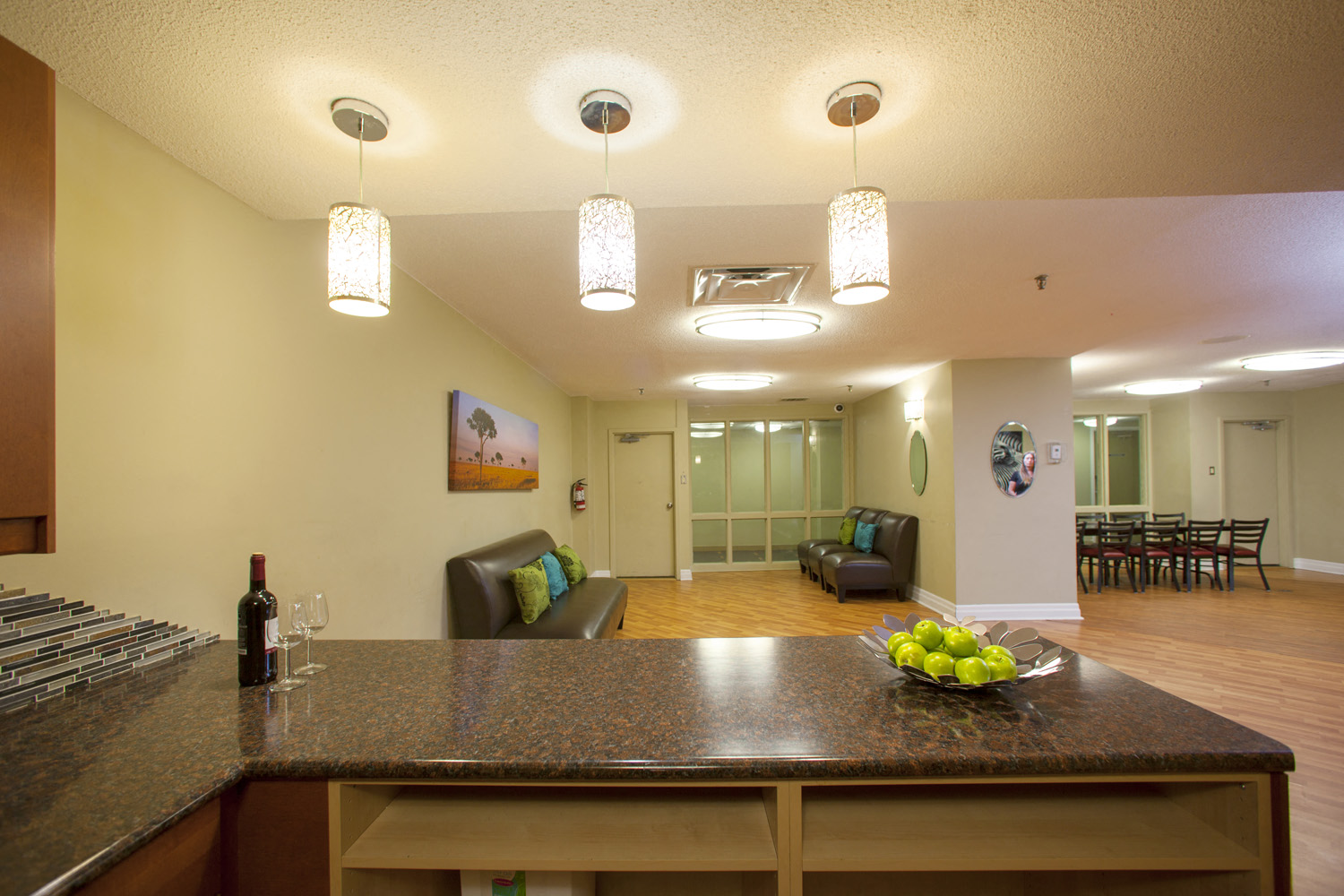 A kitchen with a brown counter top and a bowl of green apples on it.