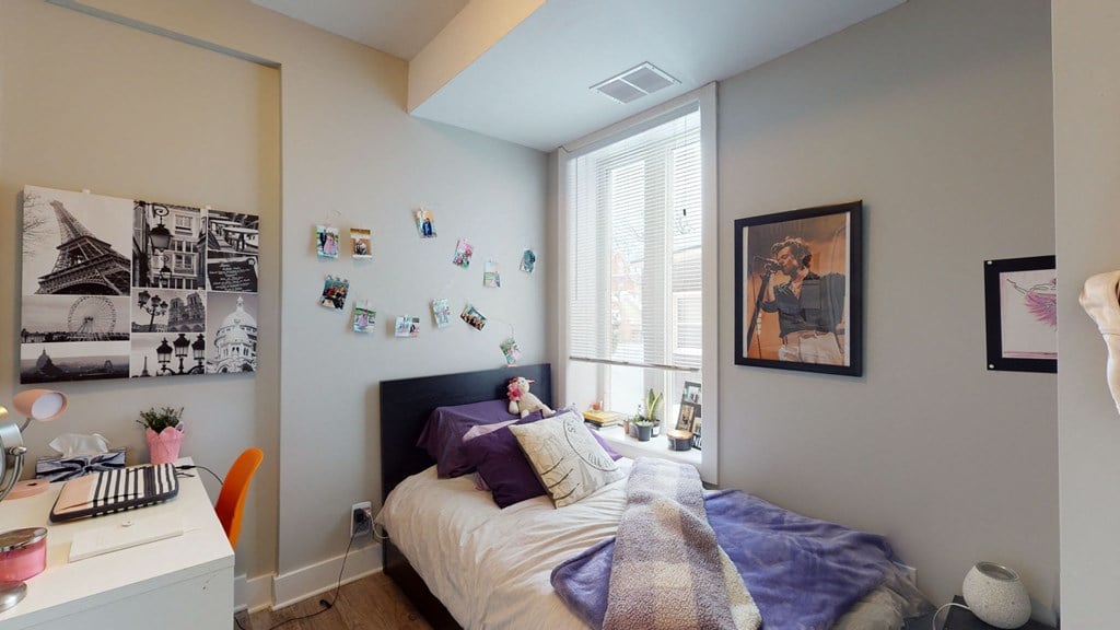 a bedroom with a bed and a desk and a window