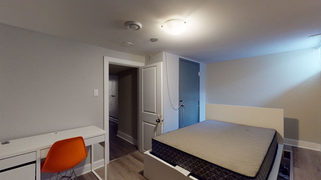 a small bedroom with a bed and a desk and a closet