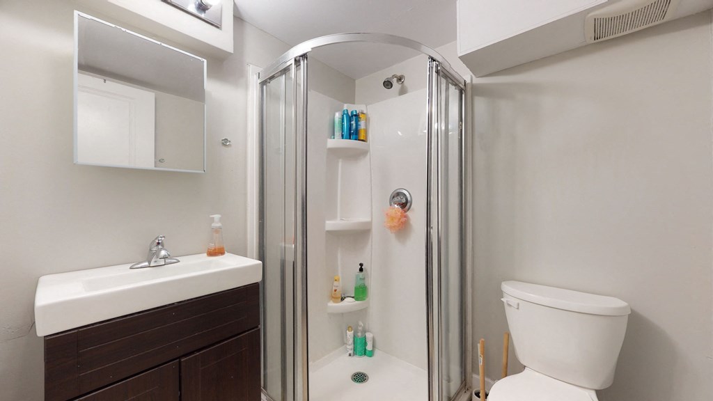 a bathroom with a shower and a sink and a toilet