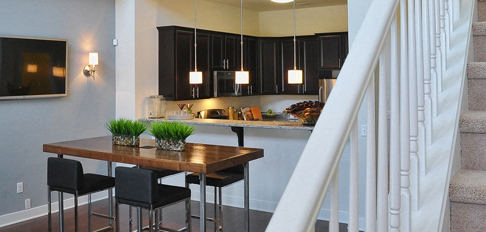 a kitchen and dining room with black cabinets and a table