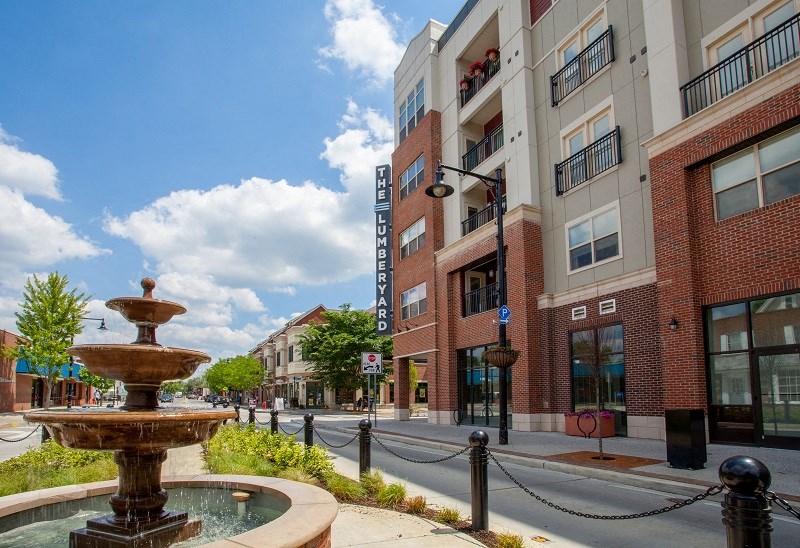 a fountain in the middle of a street in front of a building