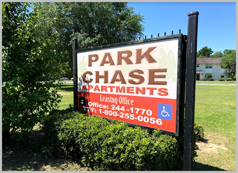 a park chase apartments sign in a park