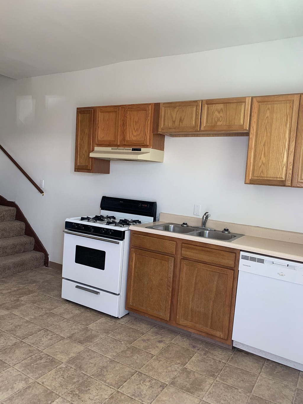 an empty kitchen with a stove and a sink