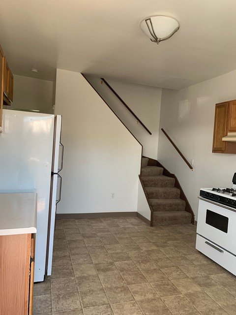 A kitchen with a staircase leading to the second floor.