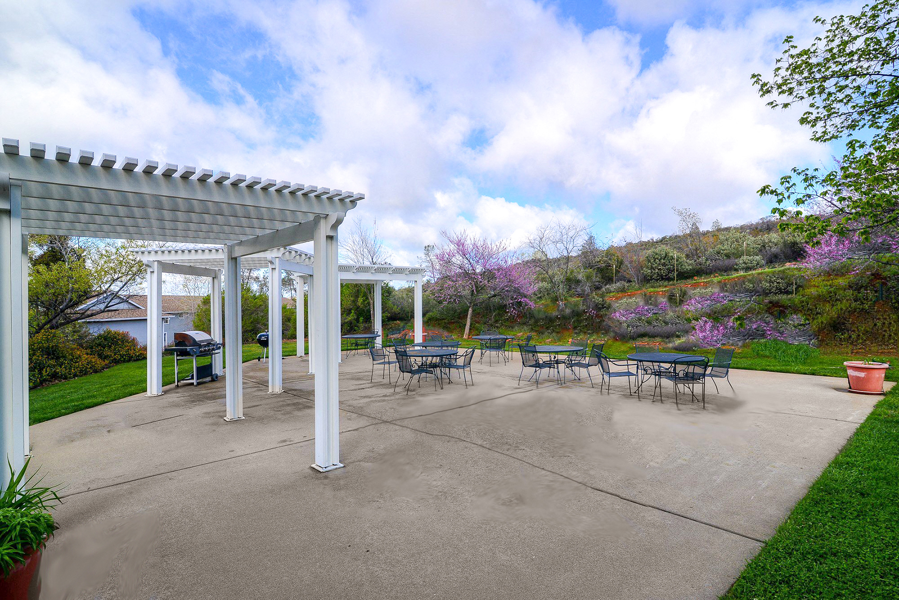 Outside community patio with grill and seating at Cameron Park Village Apartments, Cameron Park, CA
