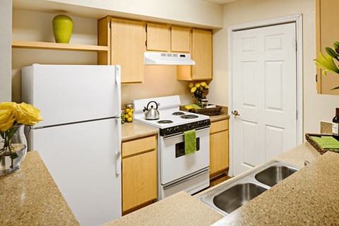 a kitchen with white appliances and wooden cabinets