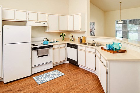 a kitchen with white cabinets and a white refrigerator