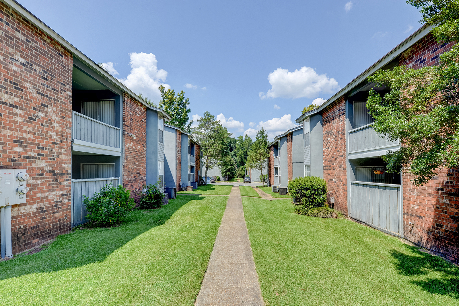 Sidewalk with buildings on either side at Landmark Apartment Homes, Meridian, Mississippi