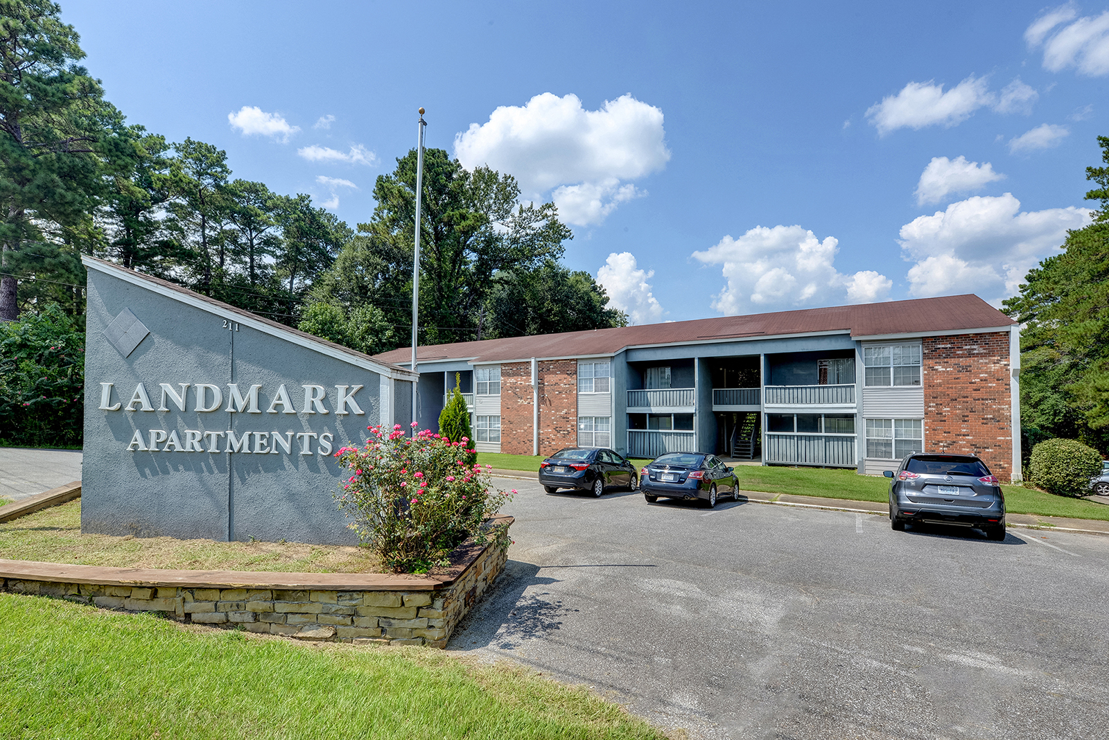 Monument sign next to parking lot and building at Landmark Apartment Homes, Meridian, MS