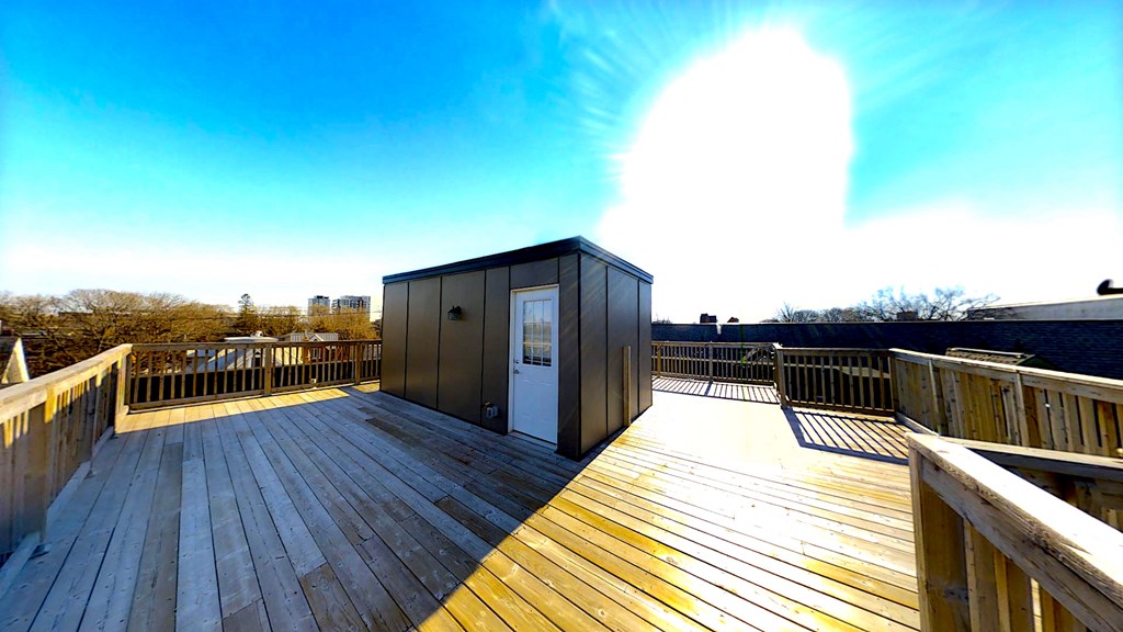 a tiny house on the top of a wooden deck