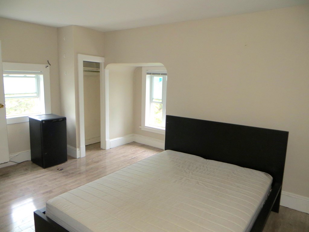 an empty bedroom with a bed and a window