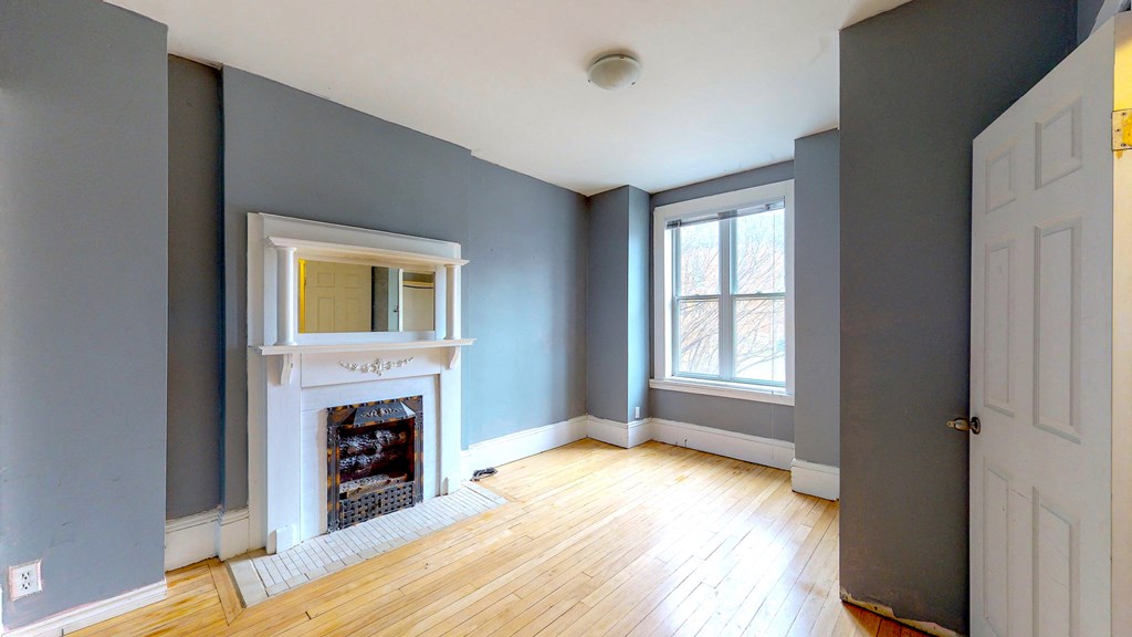 a living room with blue walls and a white fireplace