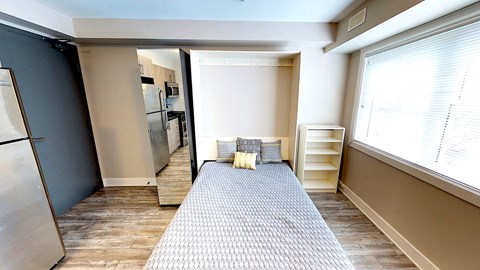 a kitchen with a large window and a rug in the middle