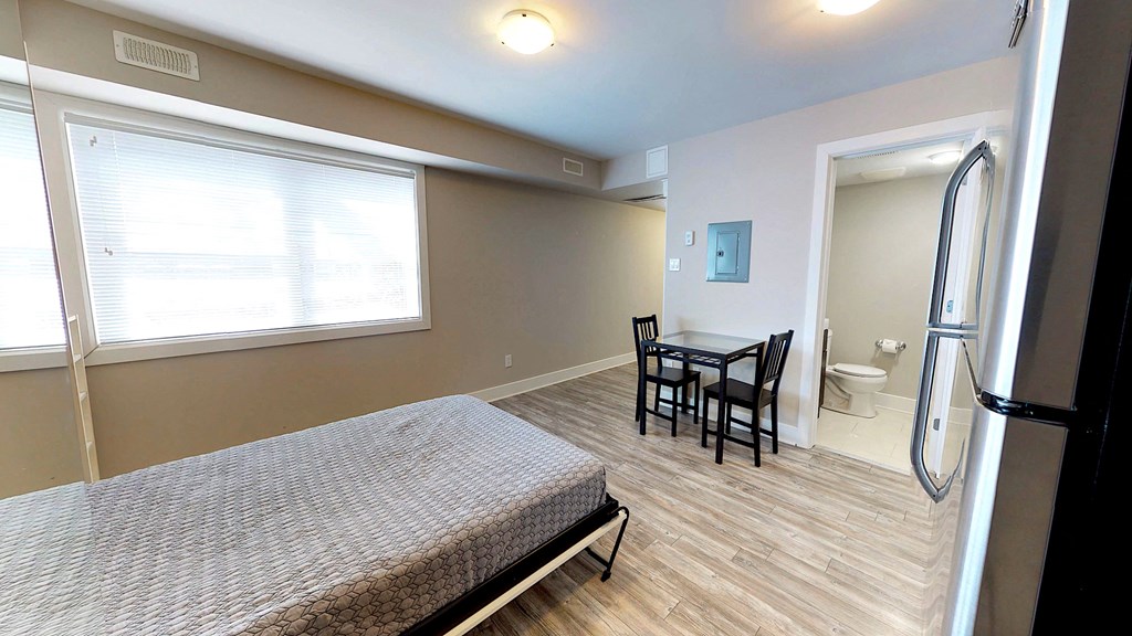 a bedroom with a bed and a bathroom with a sink