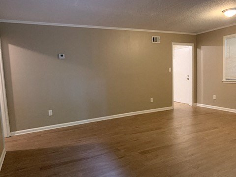 a empty living room with a wooden floor