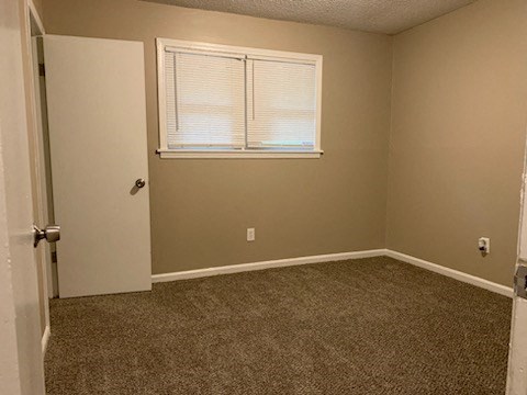 an empty room with a window and a door