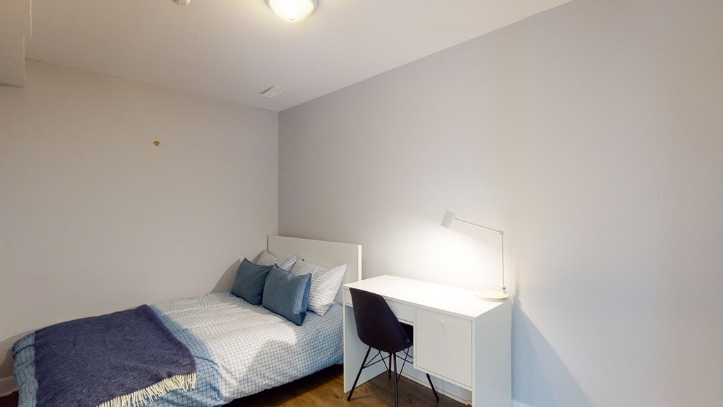 a small bedroom with a bed and a desk