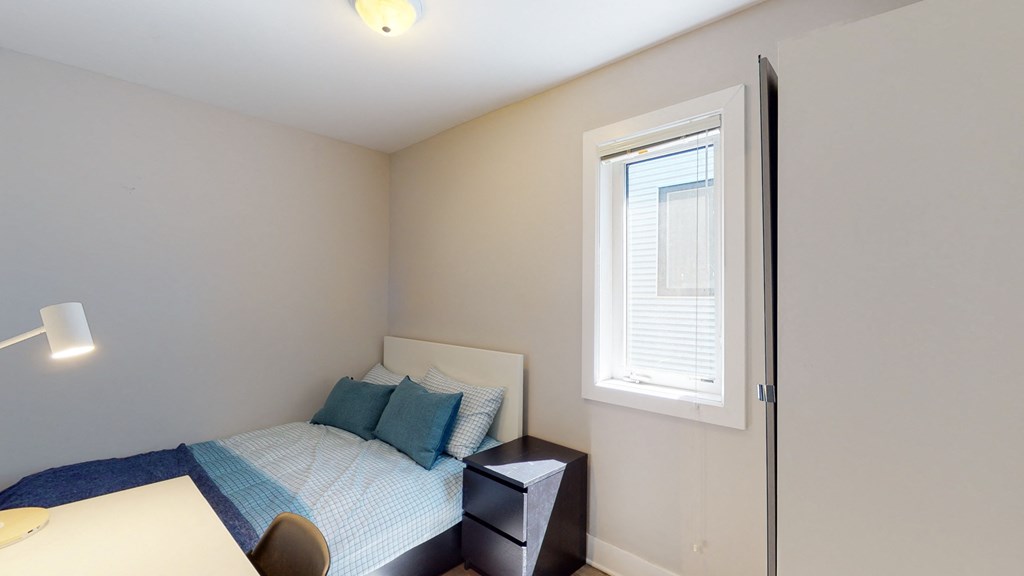 a small bedroom with a bed and a window