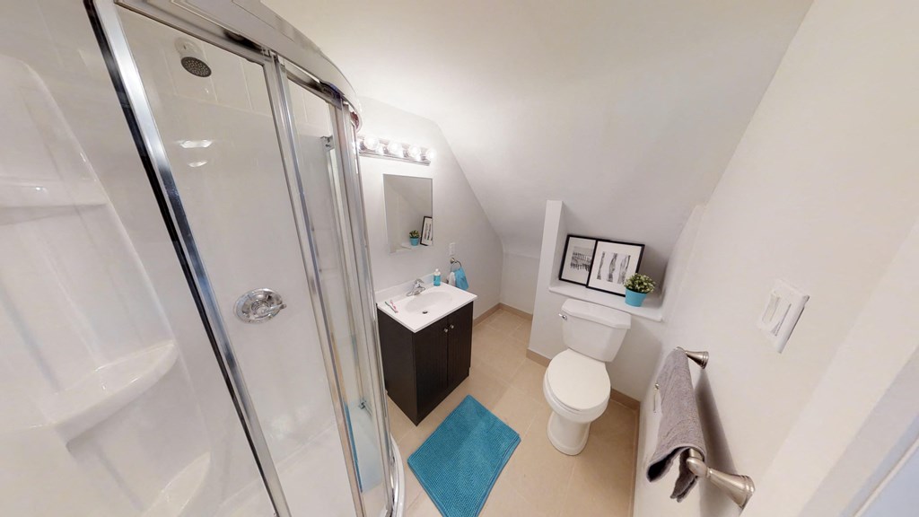 a bathroom with a shower and a toilet and a sink