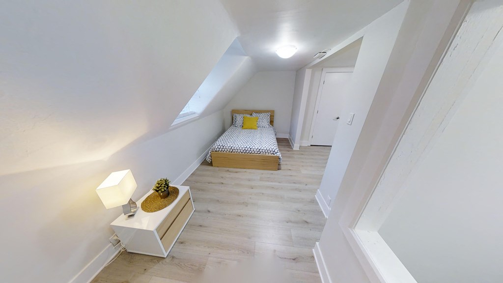 a bedroom with a bed in the middle of a white room