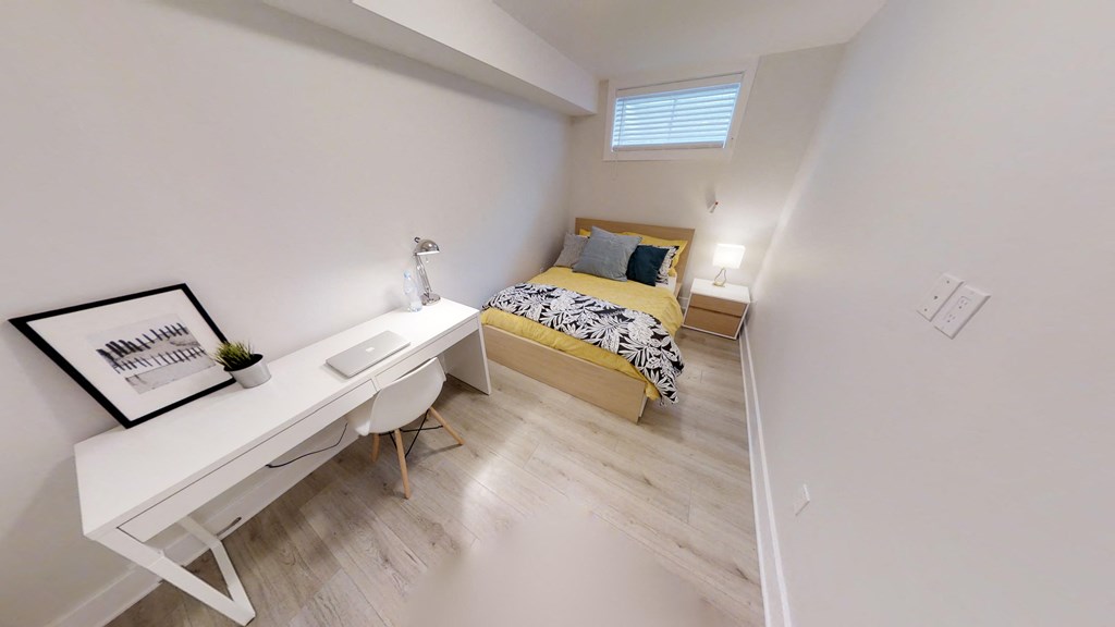 a bedroom with a desk and a bed in a room