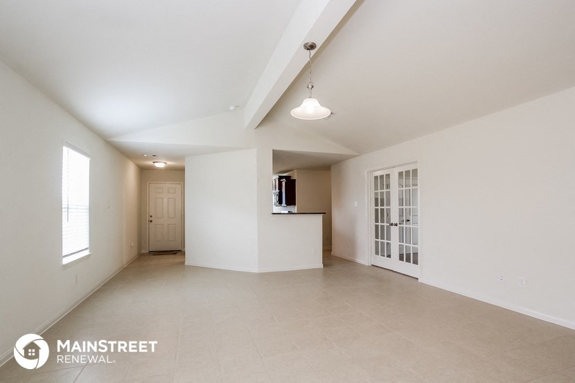 the living room and kitchen of an empty apartment