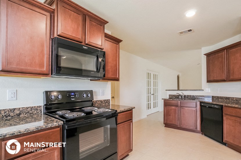 a kitchen with black appliances and wooden cabinets