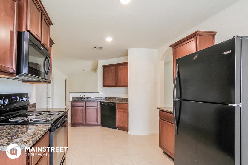 a kitchen with black appliances and wooden cabinets