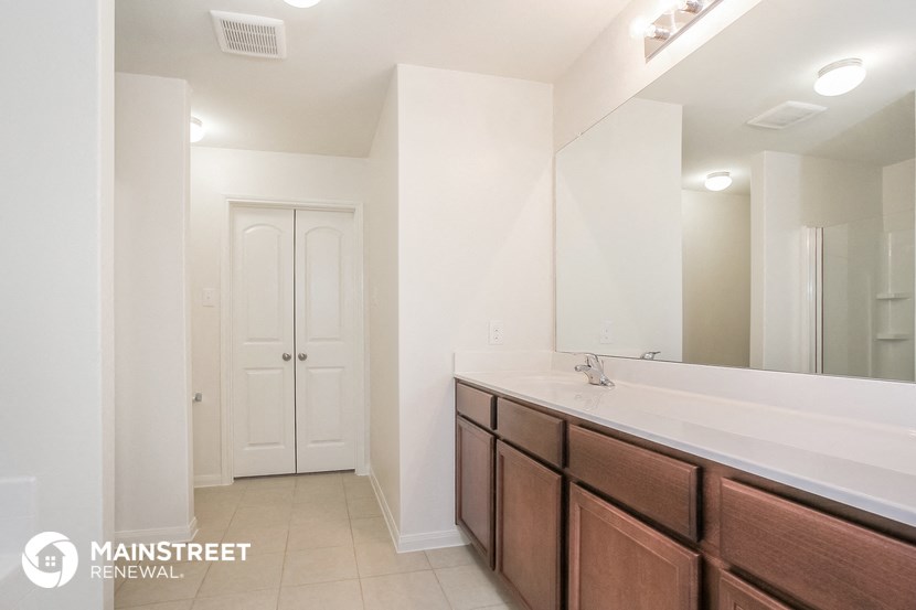 a bathroom with a sink and a mirror and a closet