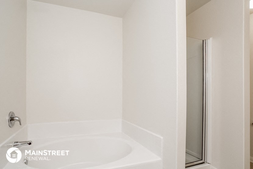 a white bathroom with a tub and a shower