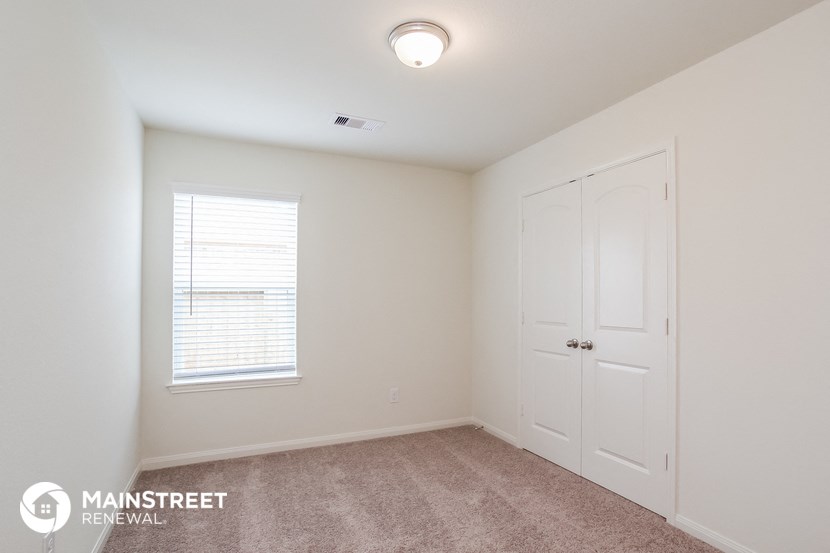 a bedroom with white walls and a white door and a window